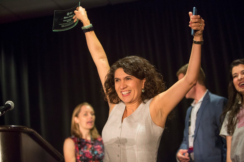 person holding award above their head